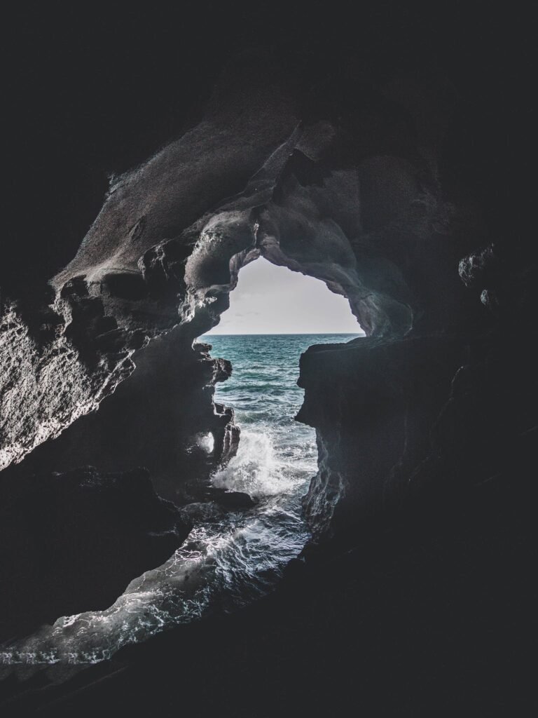 Gray Cave Near Body of Water